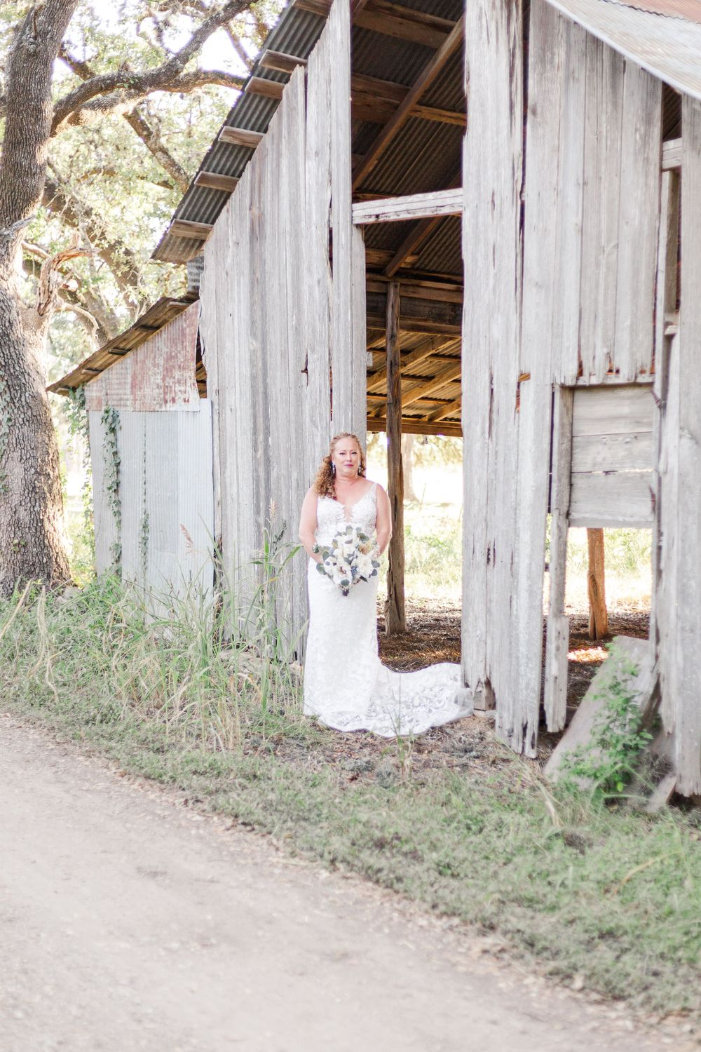 Rustic white wooden barn structures create a charming outdoor wedding venue setting.