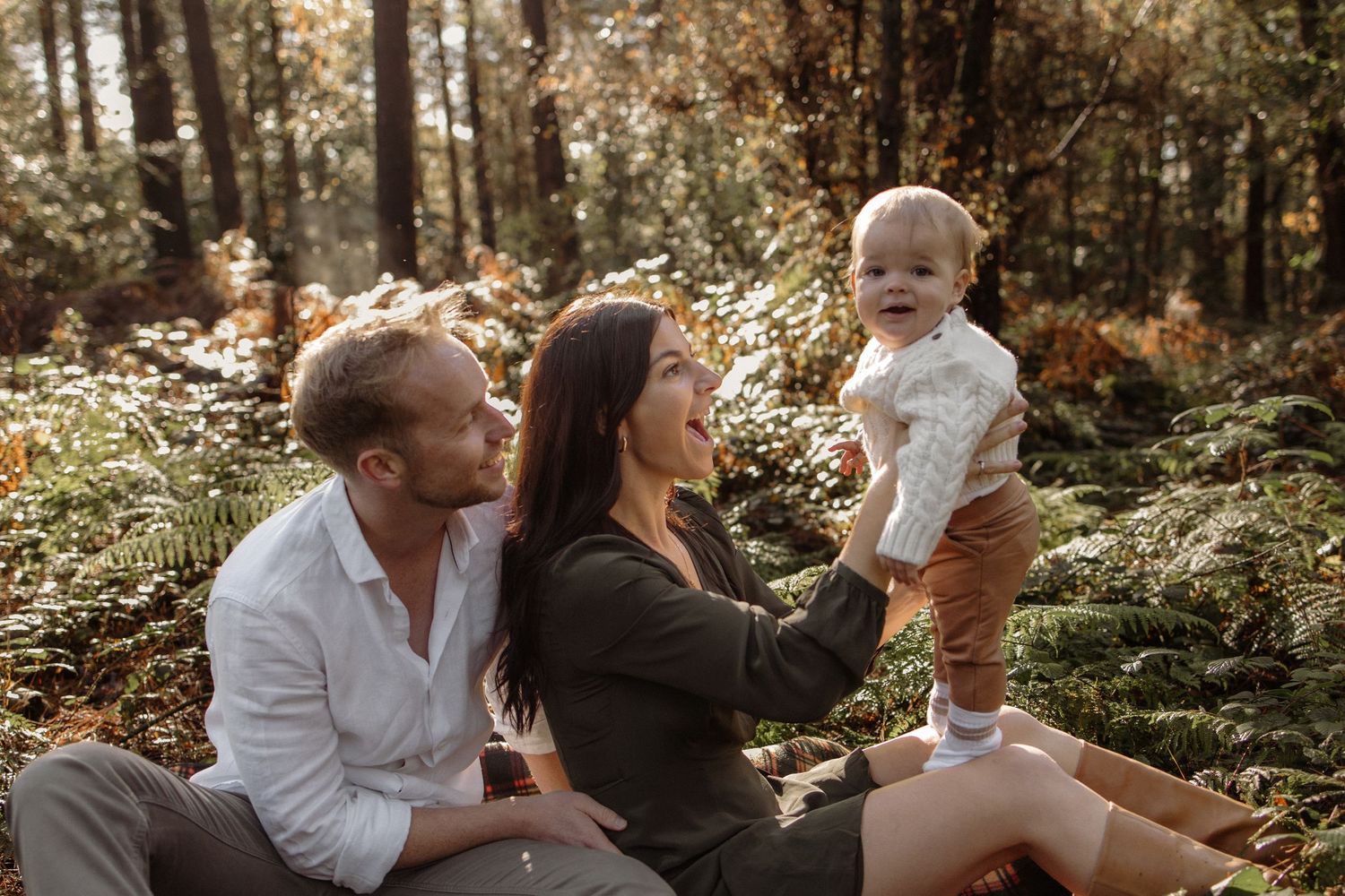 Two parents and their son in the forest during an autumn photoshoot in Hampshire.