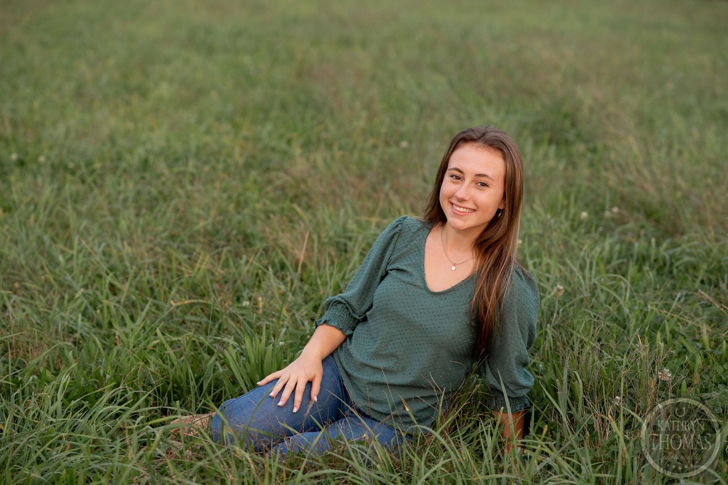 Candid outdoor portrait photograph taken in a serene grassy field during golden hour.
