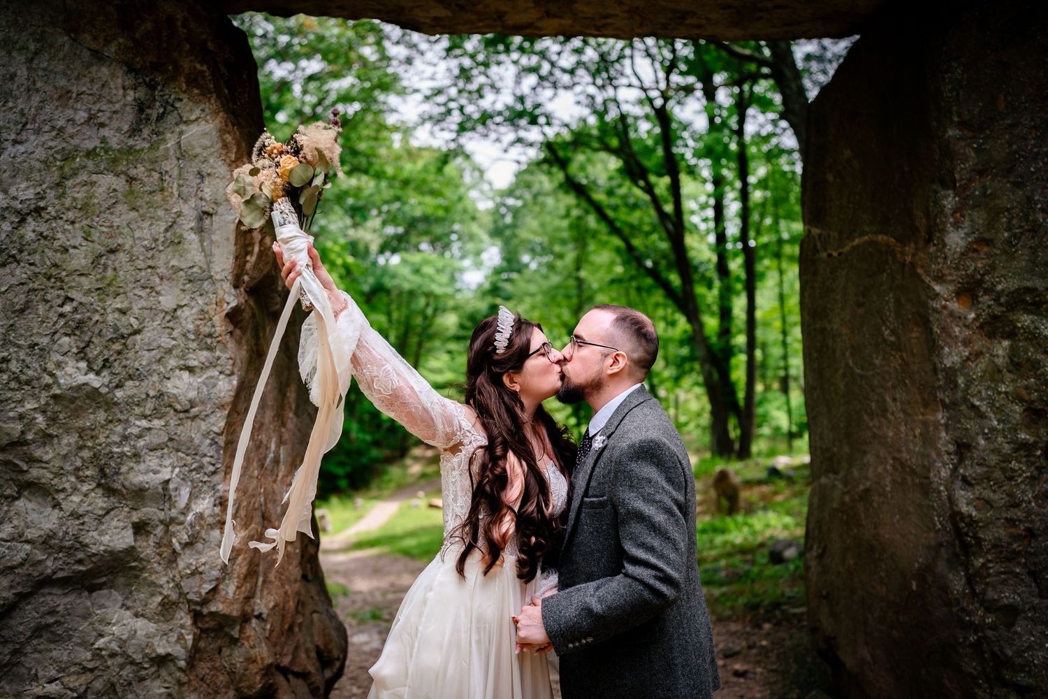 A romantic wedding photo shoot in a lush green forest setting with natural lighting and rustic elements.
