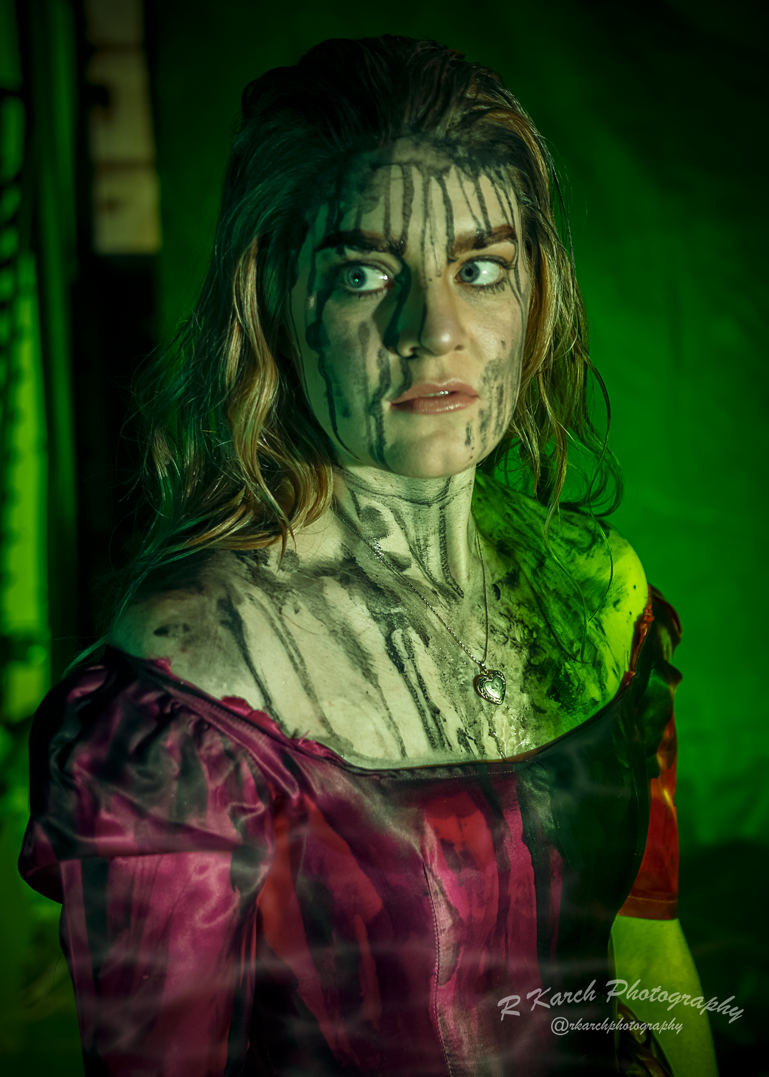 Gothic portrait bathed in eerie green light showing vintage costume and dramatic makeup.