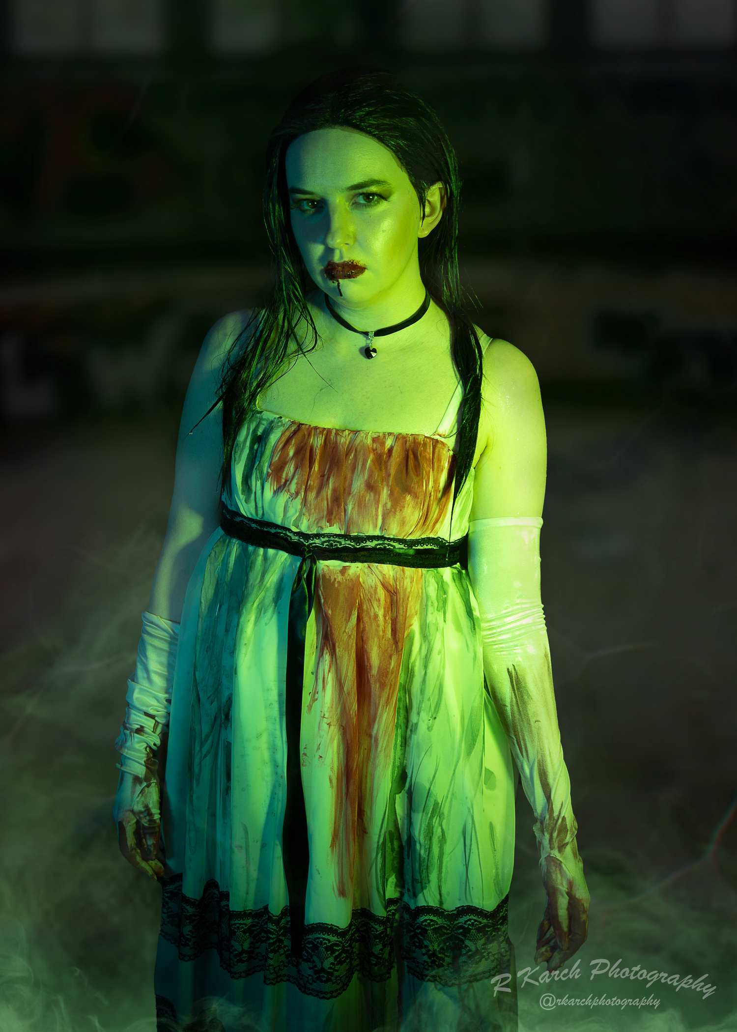 Haunting portrait in vintage dress with dramatic green lighting and fog effects.
