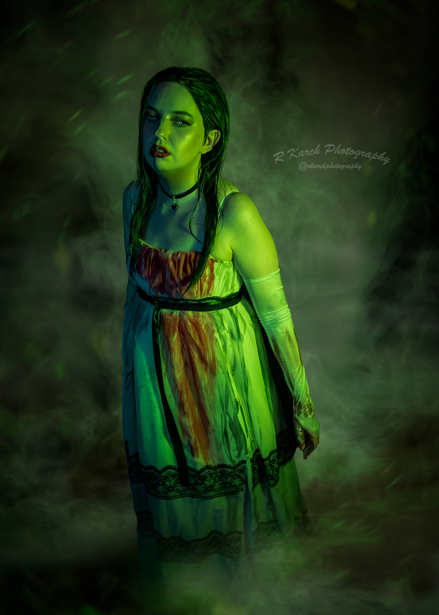 Moody gothic portrait surrounded by green fog showing vintage costume and dramatic styling.