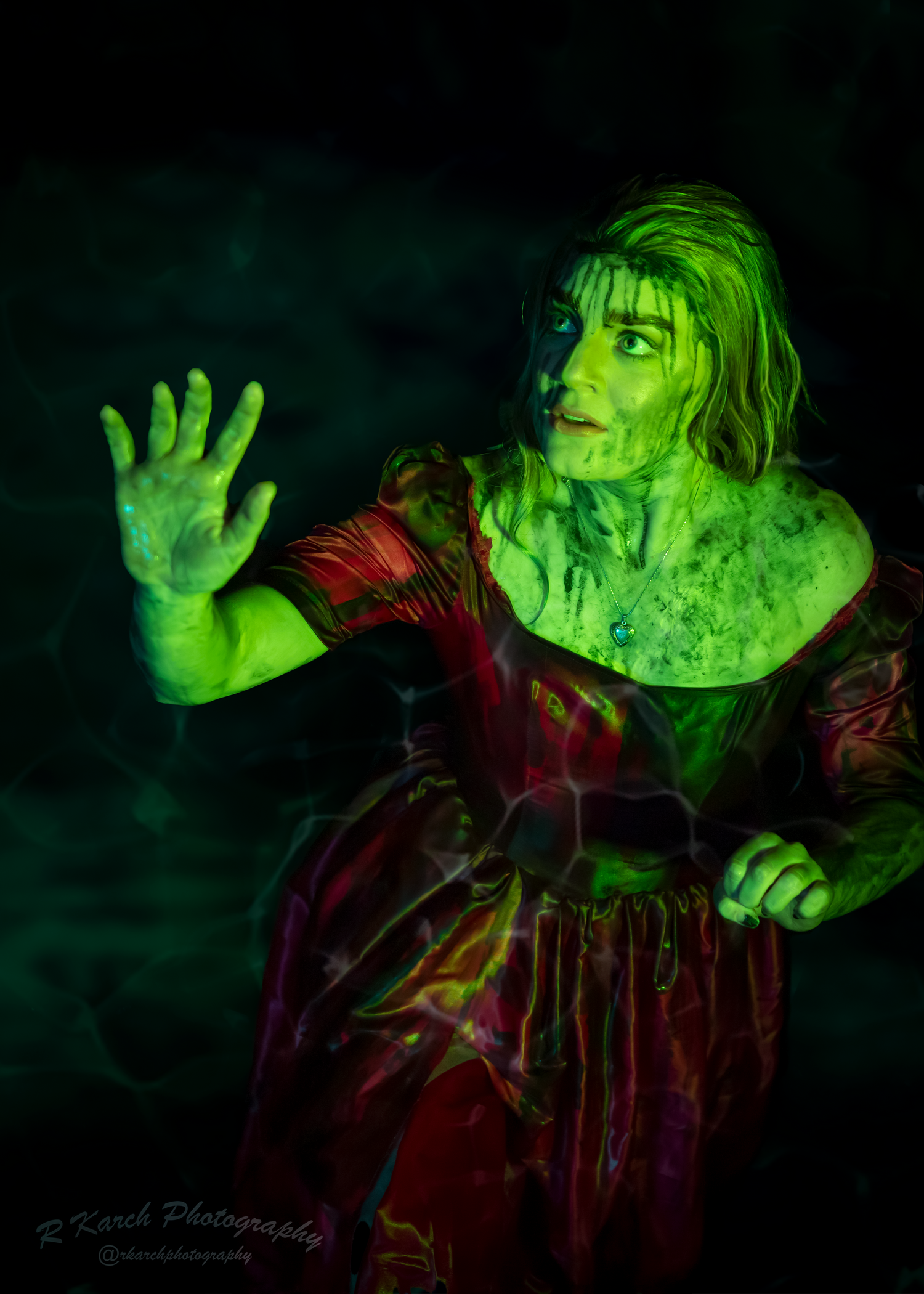 Horror-themed portrait of figure in vintage dress with supernatural green lighting effects.