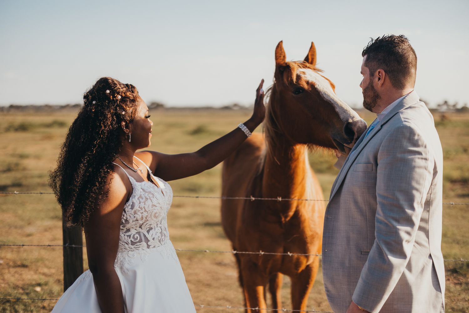 A happy interracial couple petting one of the horses at Ever After Farms.