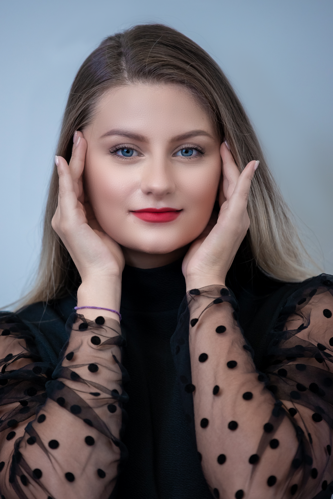 Portrait in black polka dot sheer sleeves with elegant makeup.