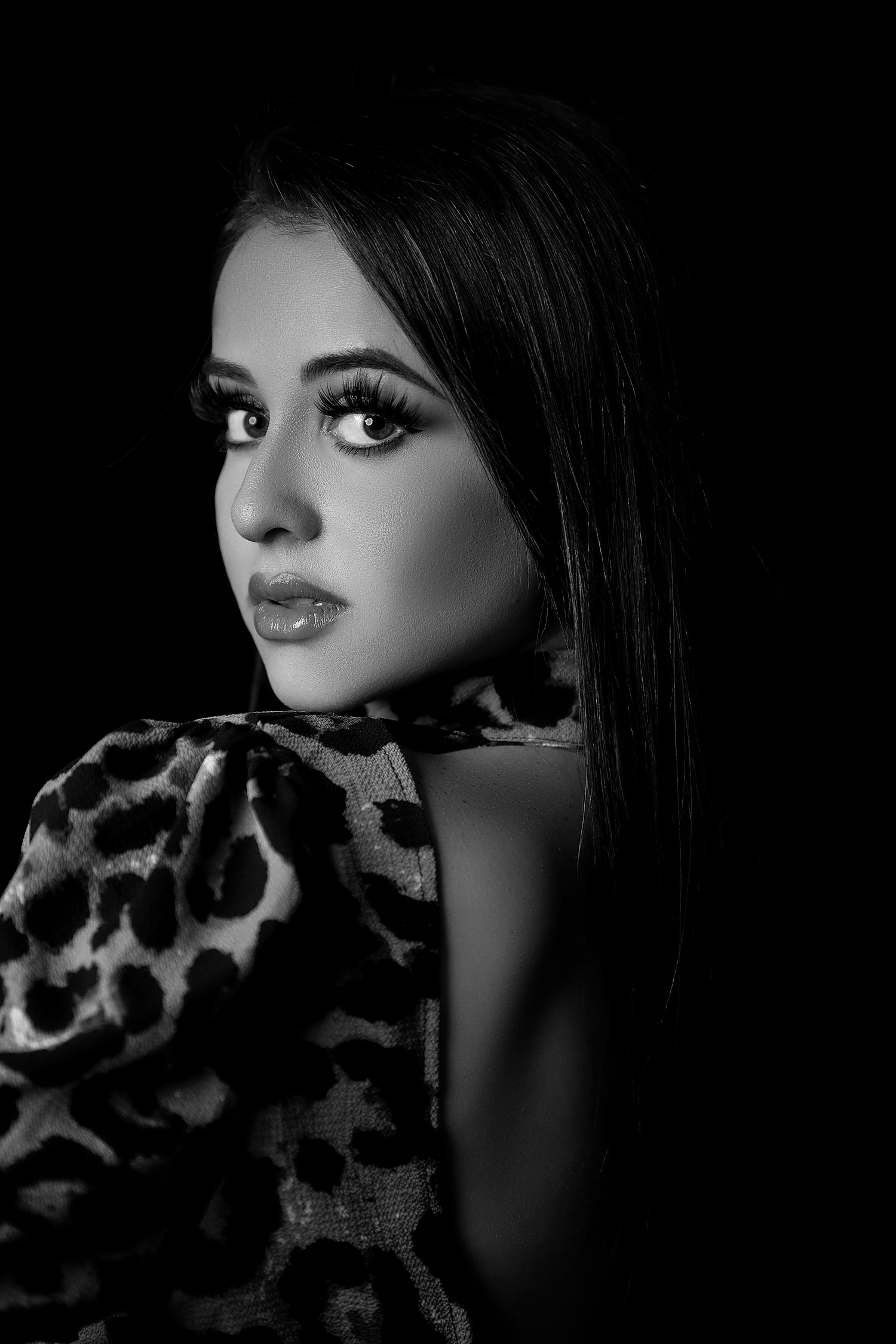 Dramatic close-up shots in black and white with animal print fabric and dramatic lighting.