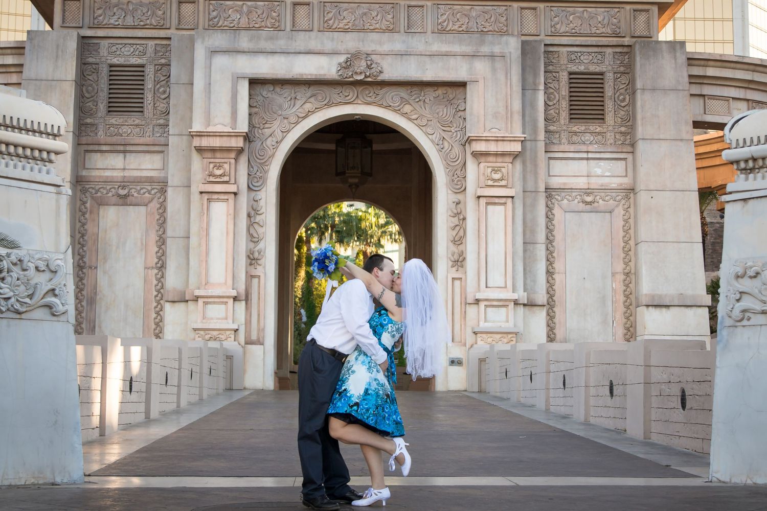 Couple standing in ornate stone archway during engagement or wedding photoshoot.