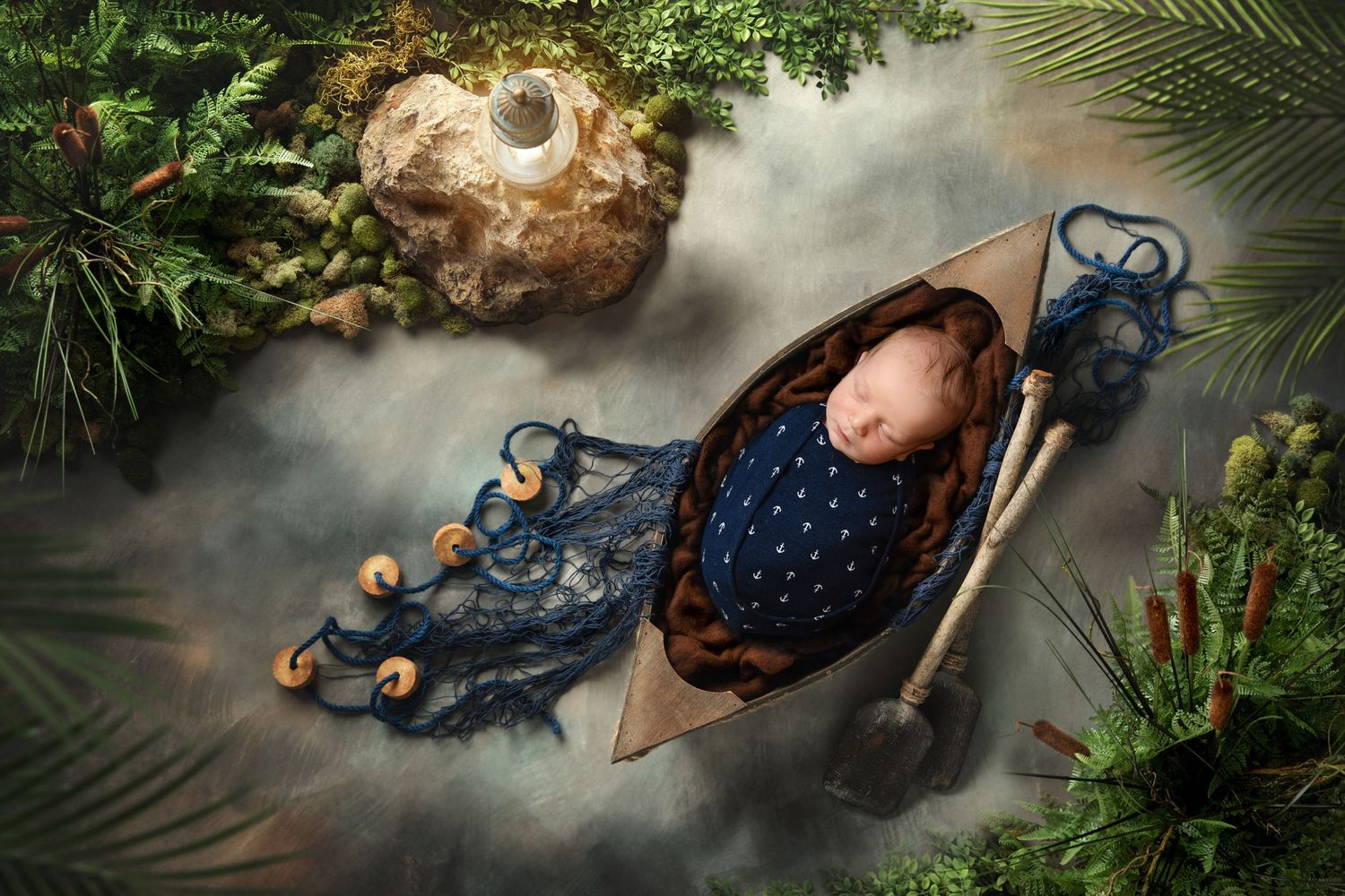 Sleeping baby in nautical outfit lying in wooden boat prop with dreamy backdrop.