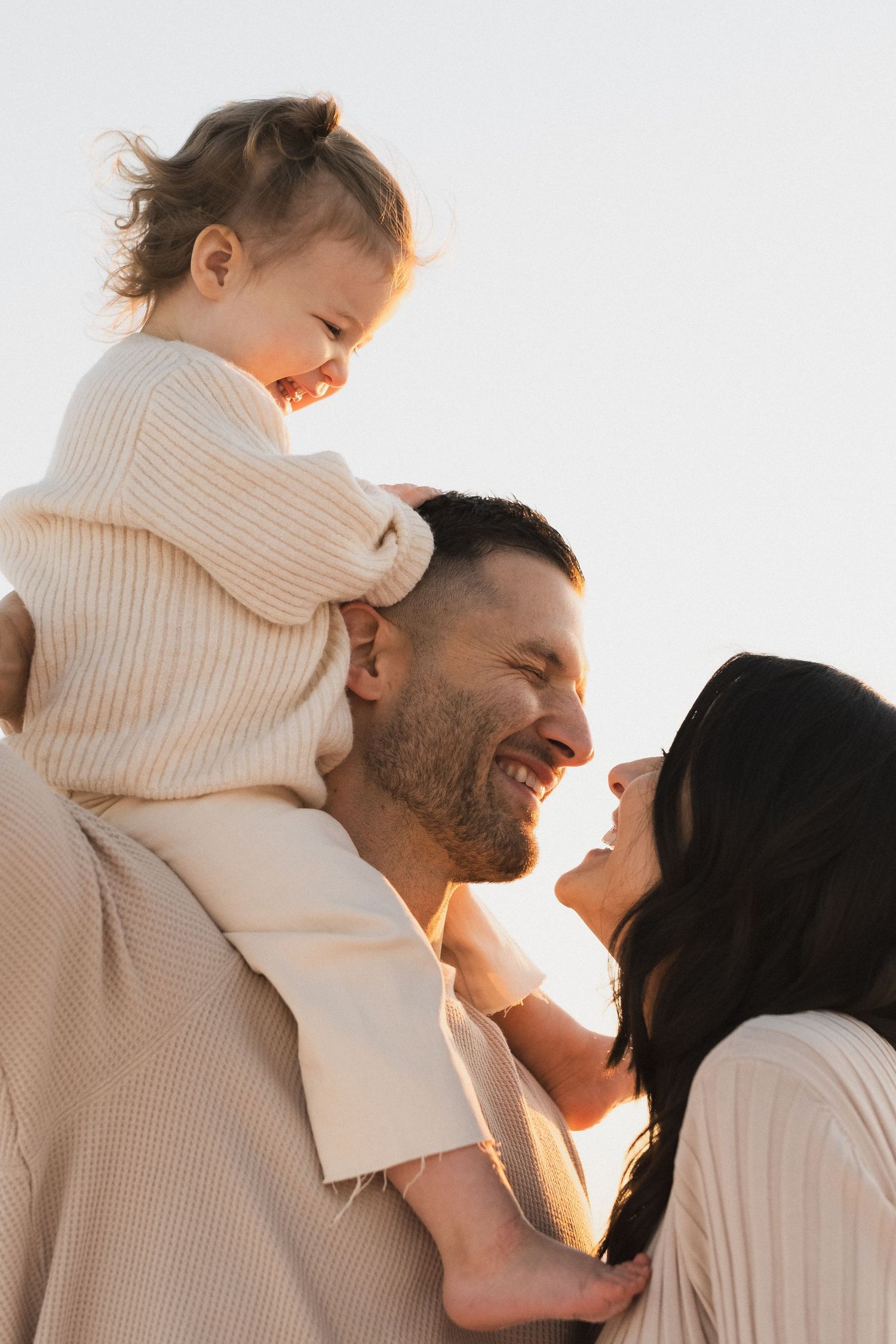A family shares joyful moments together against a bright white background.