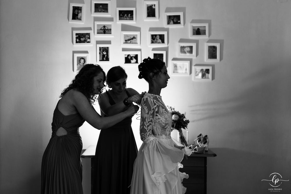 la sposa con le damigelle chiudono l'abito