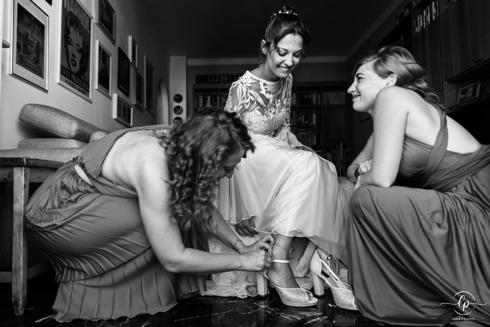 le damigelle mettono le scarpe alla sposa
