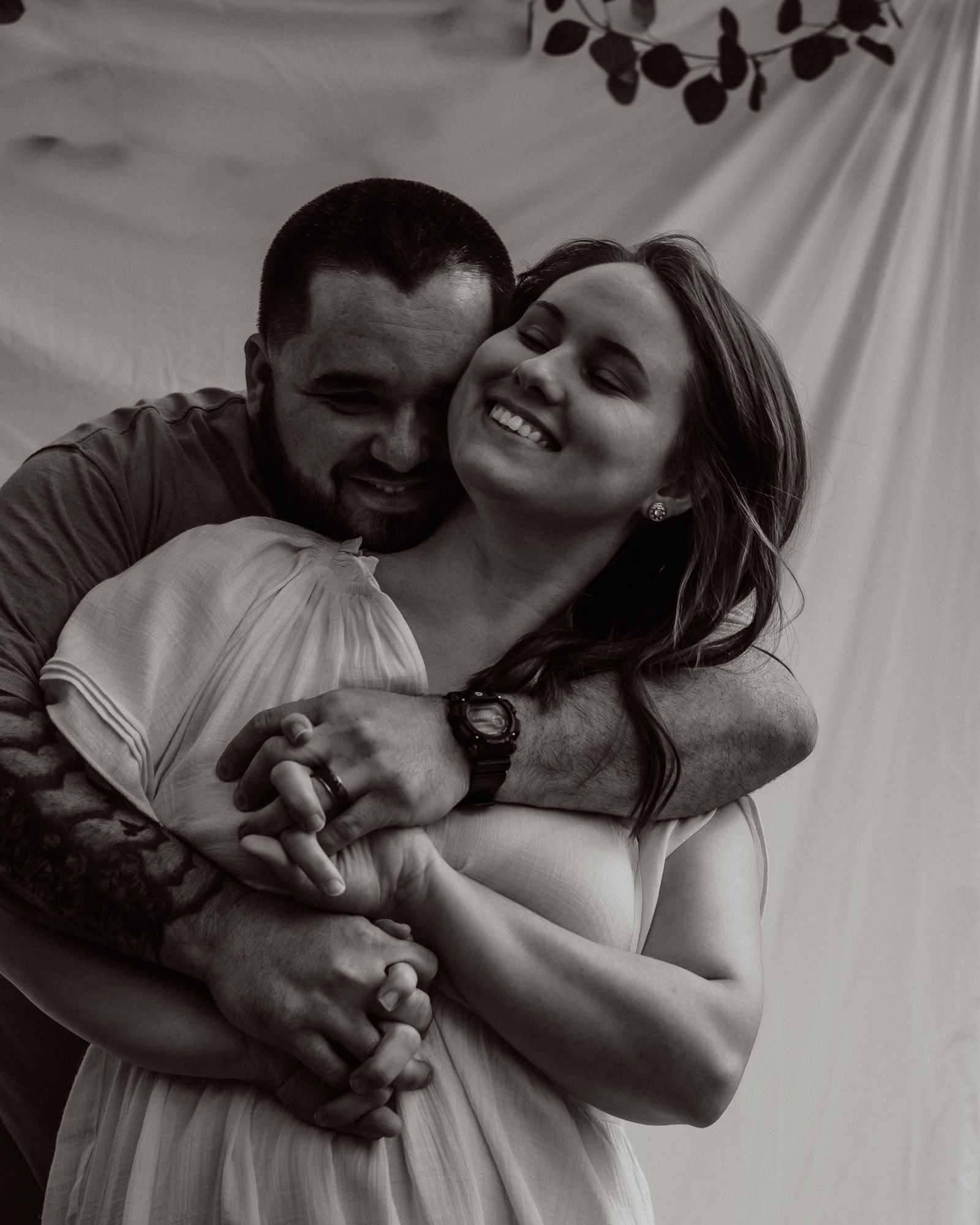 An intimate black and white portrait of a couple sharing a joyful moment together.