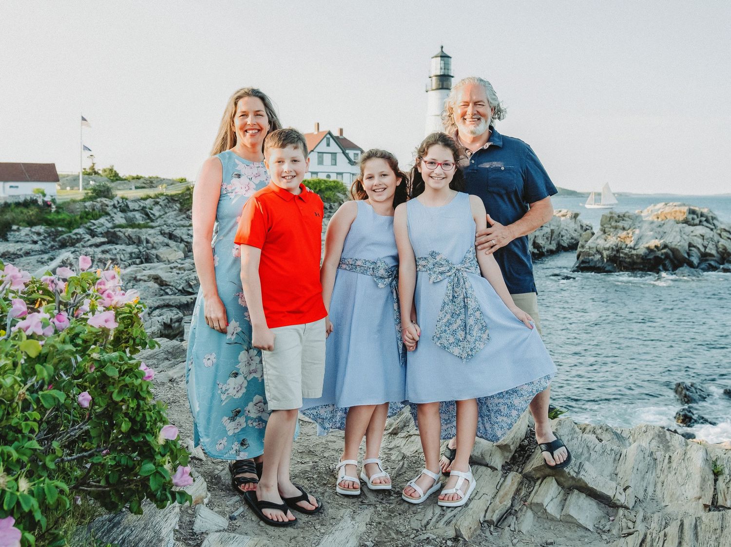 A family poses in front of the Portland Head Light Lighthouse in Cape Elizabeth, Maine.