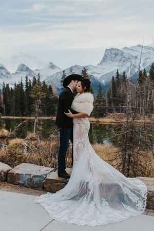 Bride and cowboy groom kiss in Canmore mountains