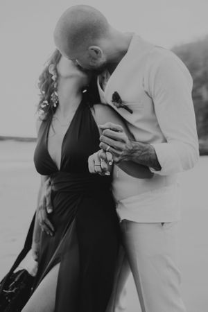 Couple kiss and embrace with pinkies interlocked