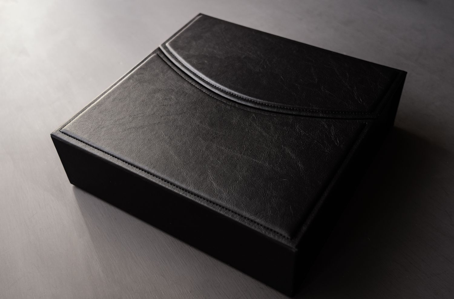 Elegant black leather album boxes arranged in minimalist composition.