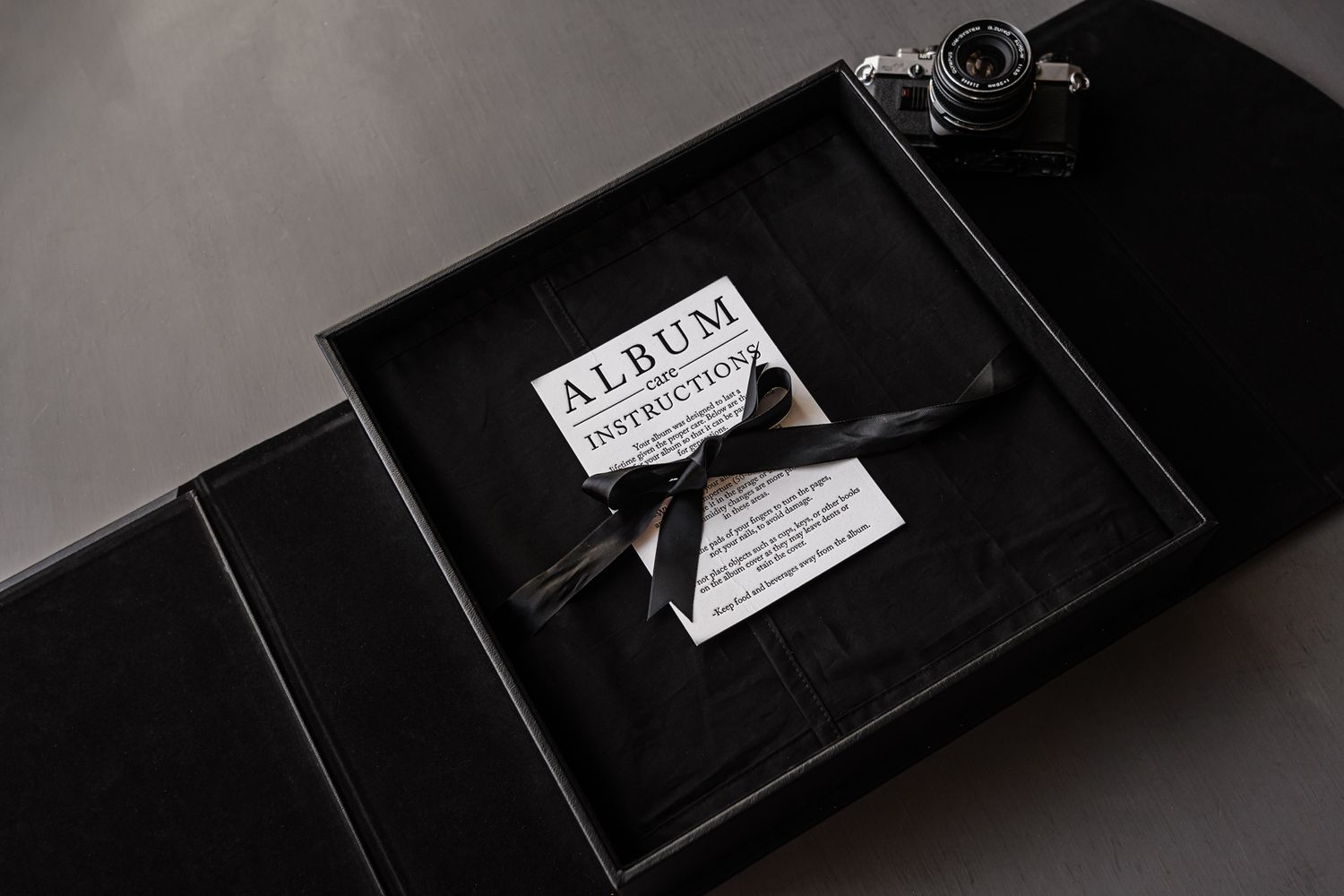 Professional black leather portfolio box with embossed details in dramatic lighting.