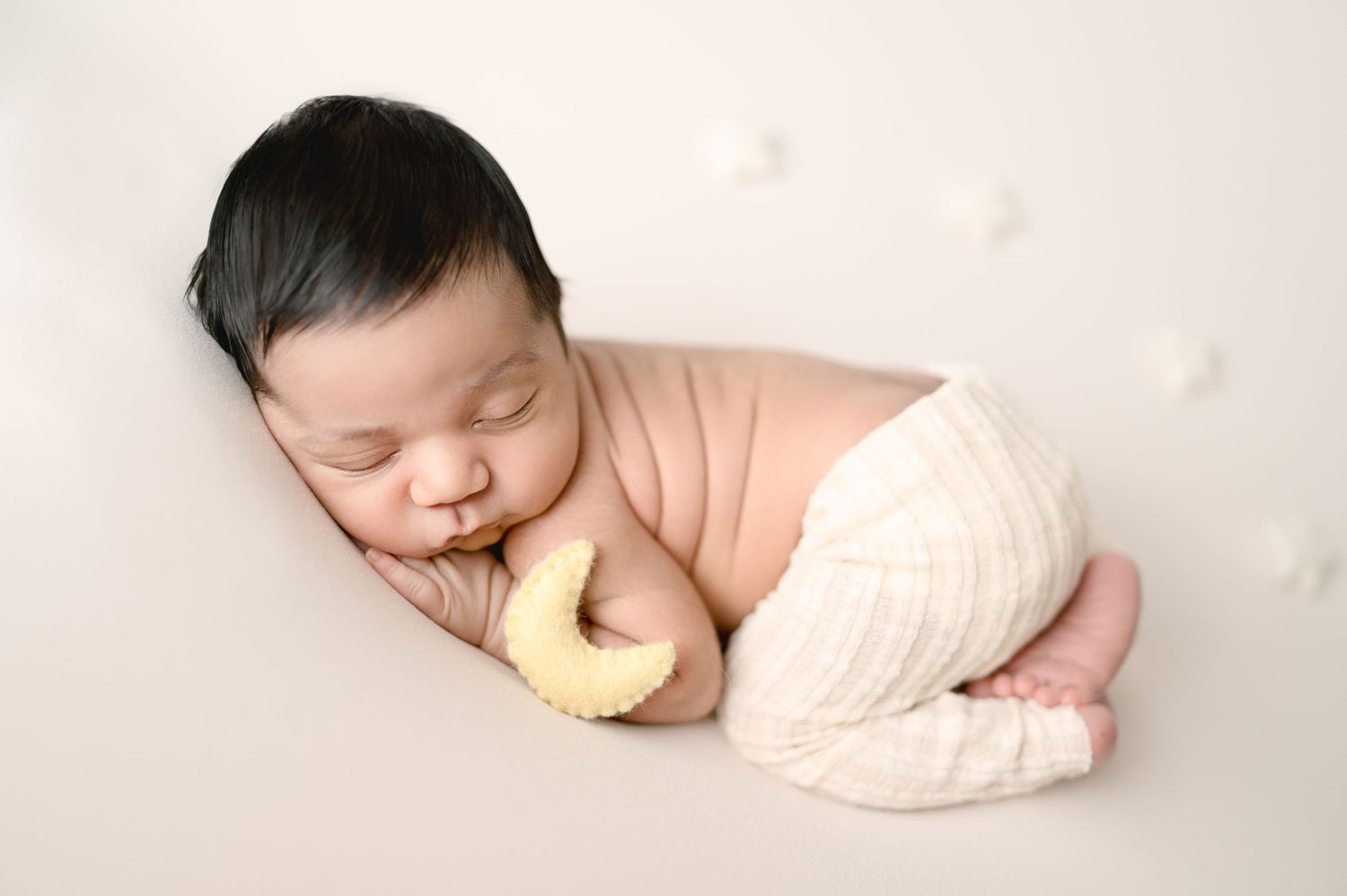 Peaceful sleeping baby with yellow comfort pillow in white diaper.