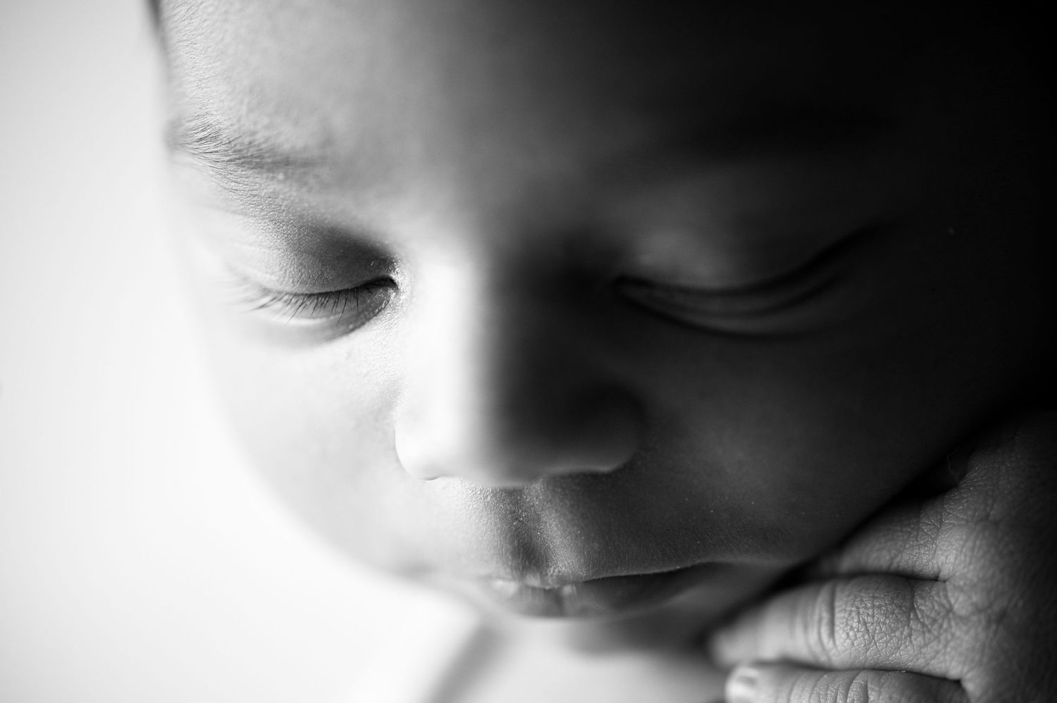 Close-up black and white macro shot highlighting delicate newborn features.