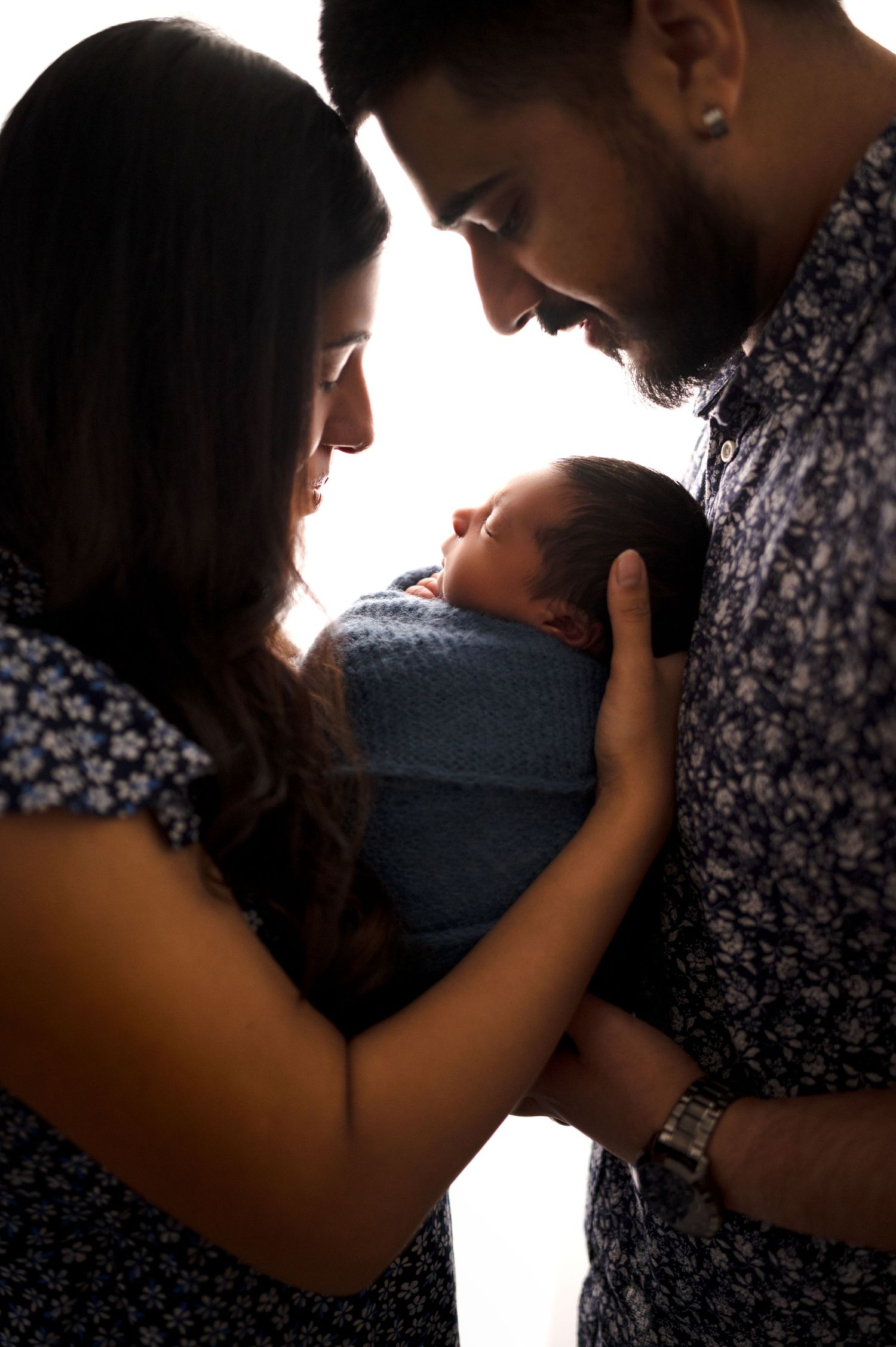 Intimate silhouette portraits showing tender family moments against bright white background.