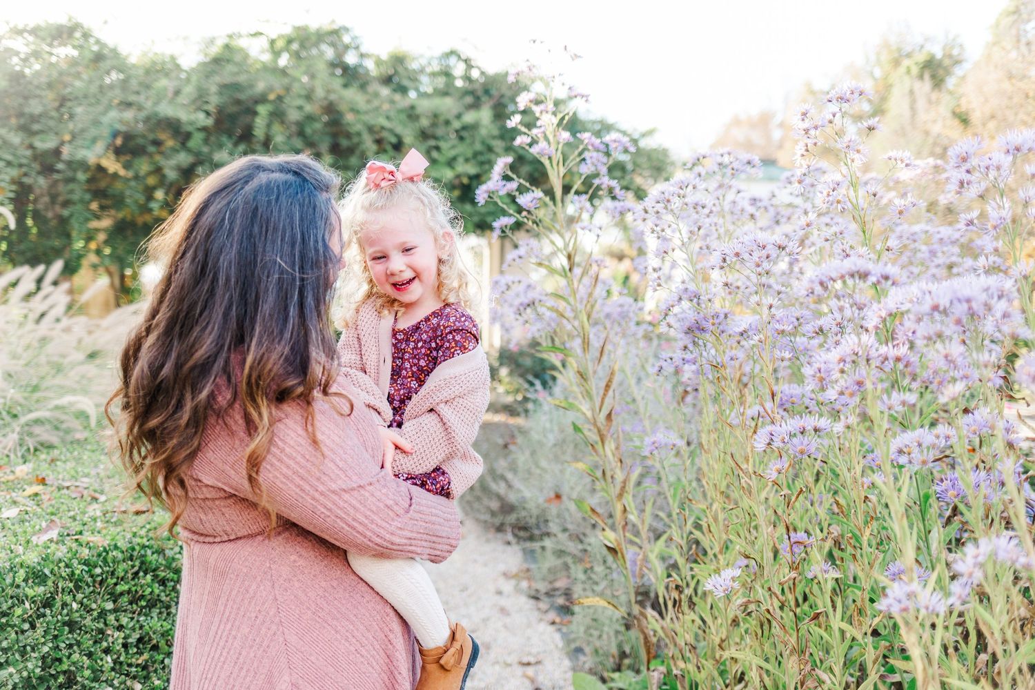 Mother and daughter laughing and smiling next to purple flowers during a Red hook, NY family session