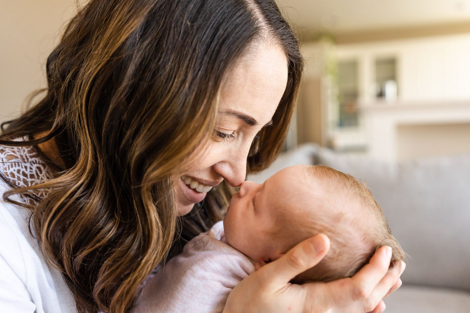 Mom doing nose kisses with newborn daughter.