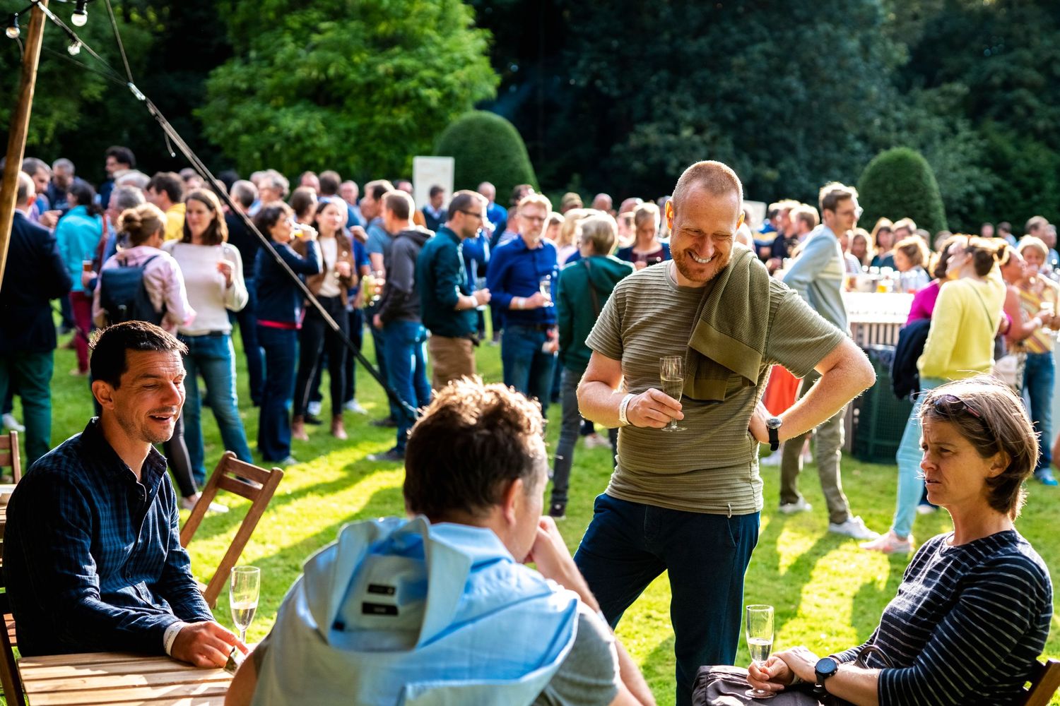 Outdoor gathering with people enjoying activities and games on a sunny day.