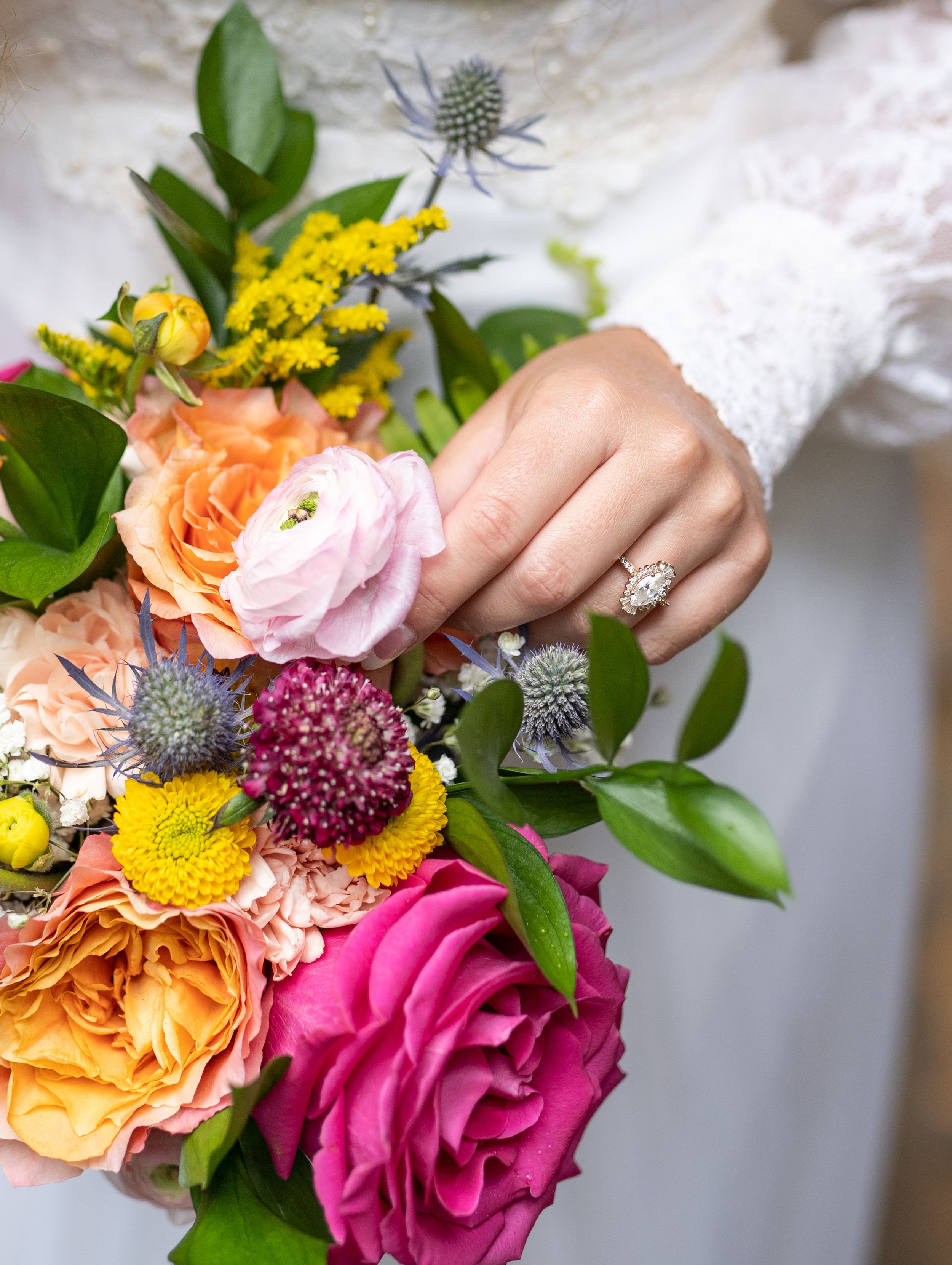 Close-up of colorful bridal bouquet featuring pink roses and yellow blooms.