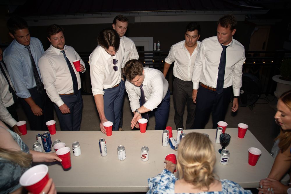 Wedding reception party with red solo cups on tables in evening lighting.