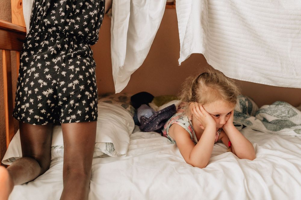 cousins building a blanket fort on their bunk beds in their sandbridge beach, virginia vacation home