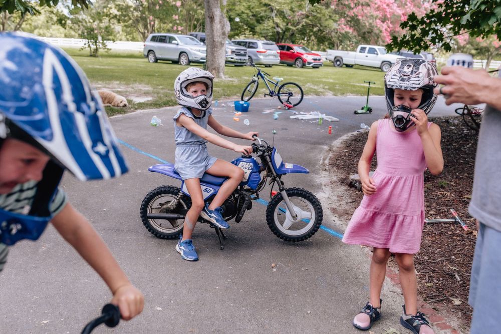 kids on dirt bikes in helmets on the driveway of the family's home day in the life session eastern shore virginia