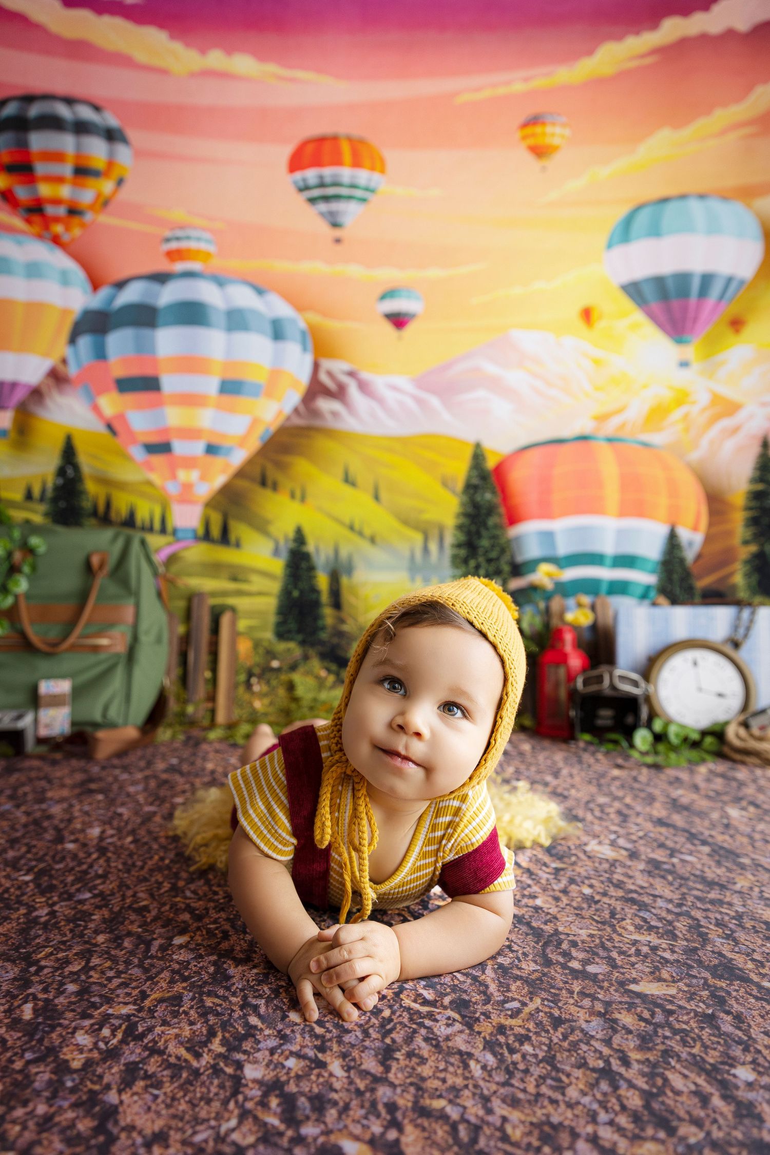 bebe vestido de amarillo y rojo fotografiado en escenario colorido con globos aereos detres photography
