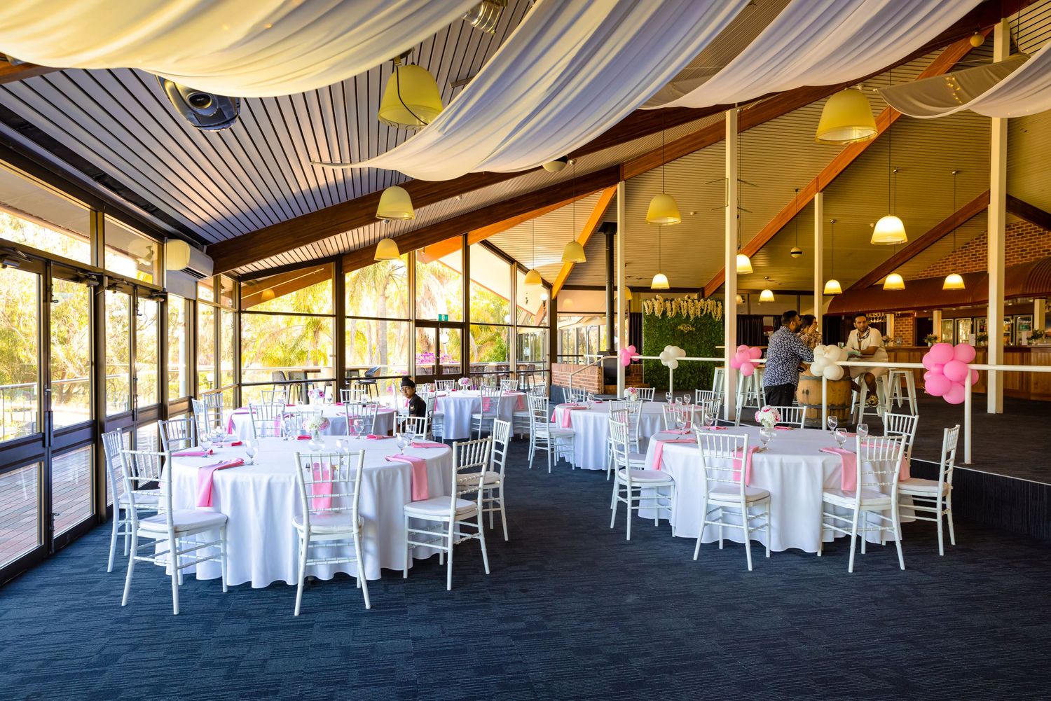 White reception tent venue with draped fabric ceiling and round dining tables set for an elegant event.