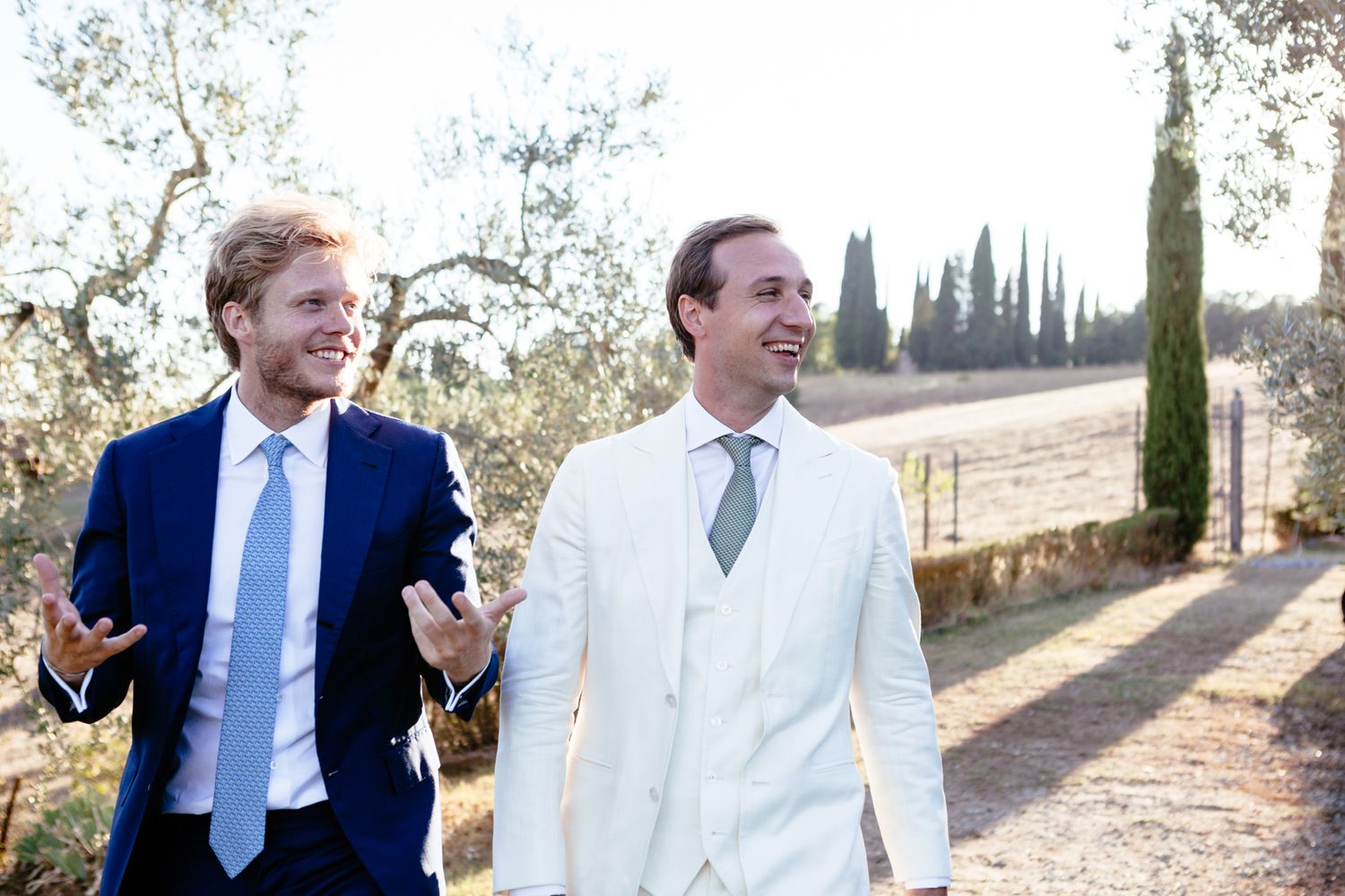 bestman and groom in white suite walk together