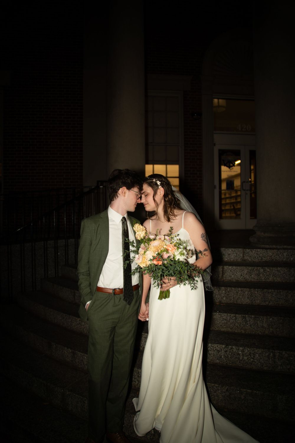 A romantic evening wedding portrait with a flowing white dress and bouquet.