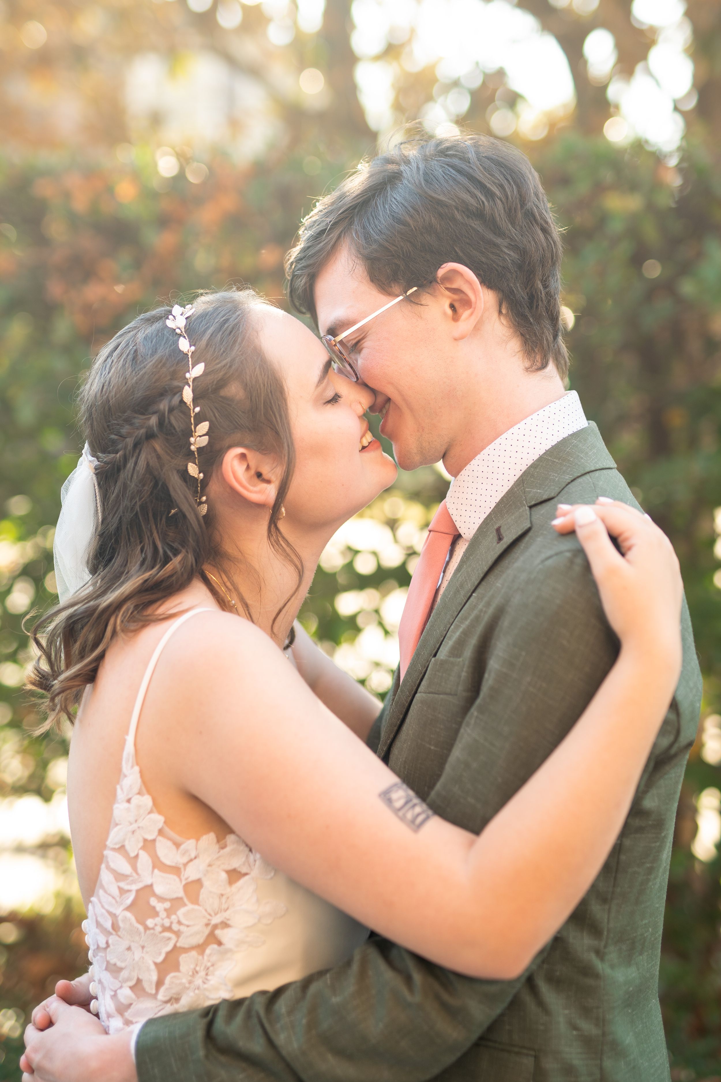 Intimate wedding couple moment captured in warm sunset lighting.
