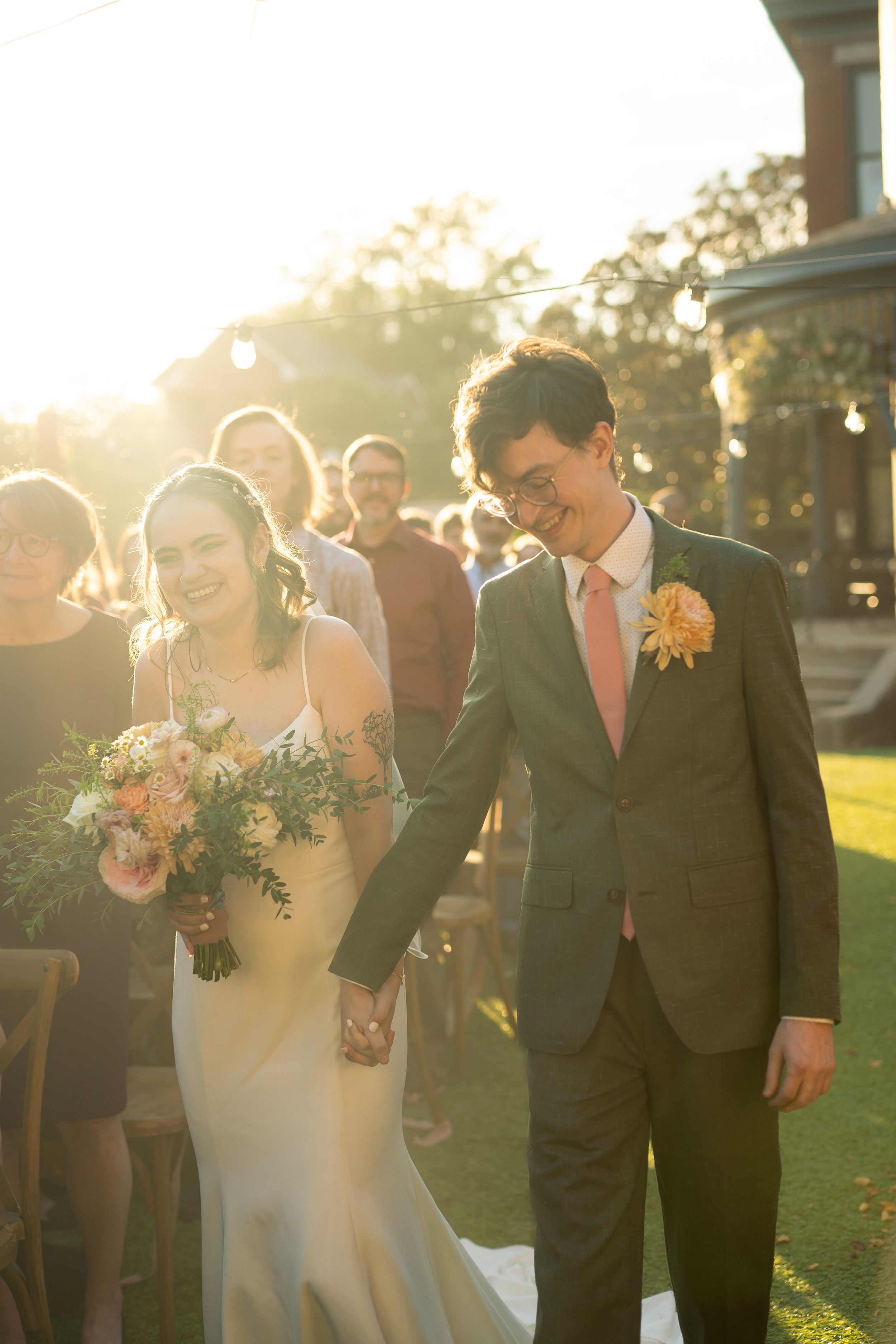 Wedding couple walks together during golden hour sunset photography session.