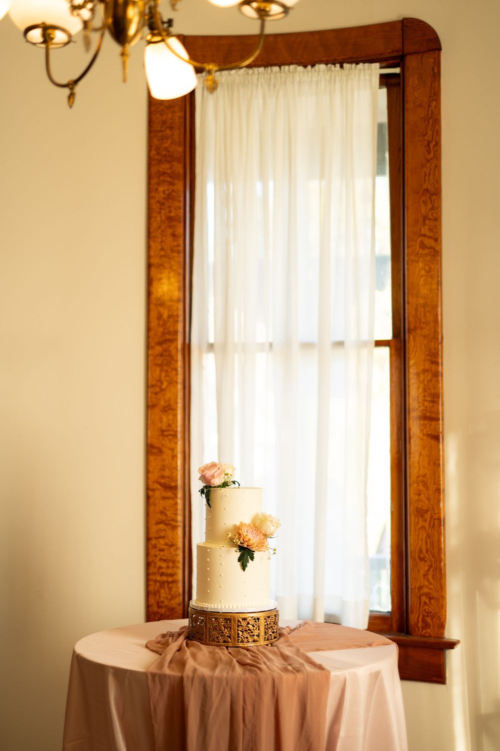 Interior detail of wedding venue with warm wood trim and sheer curtains.