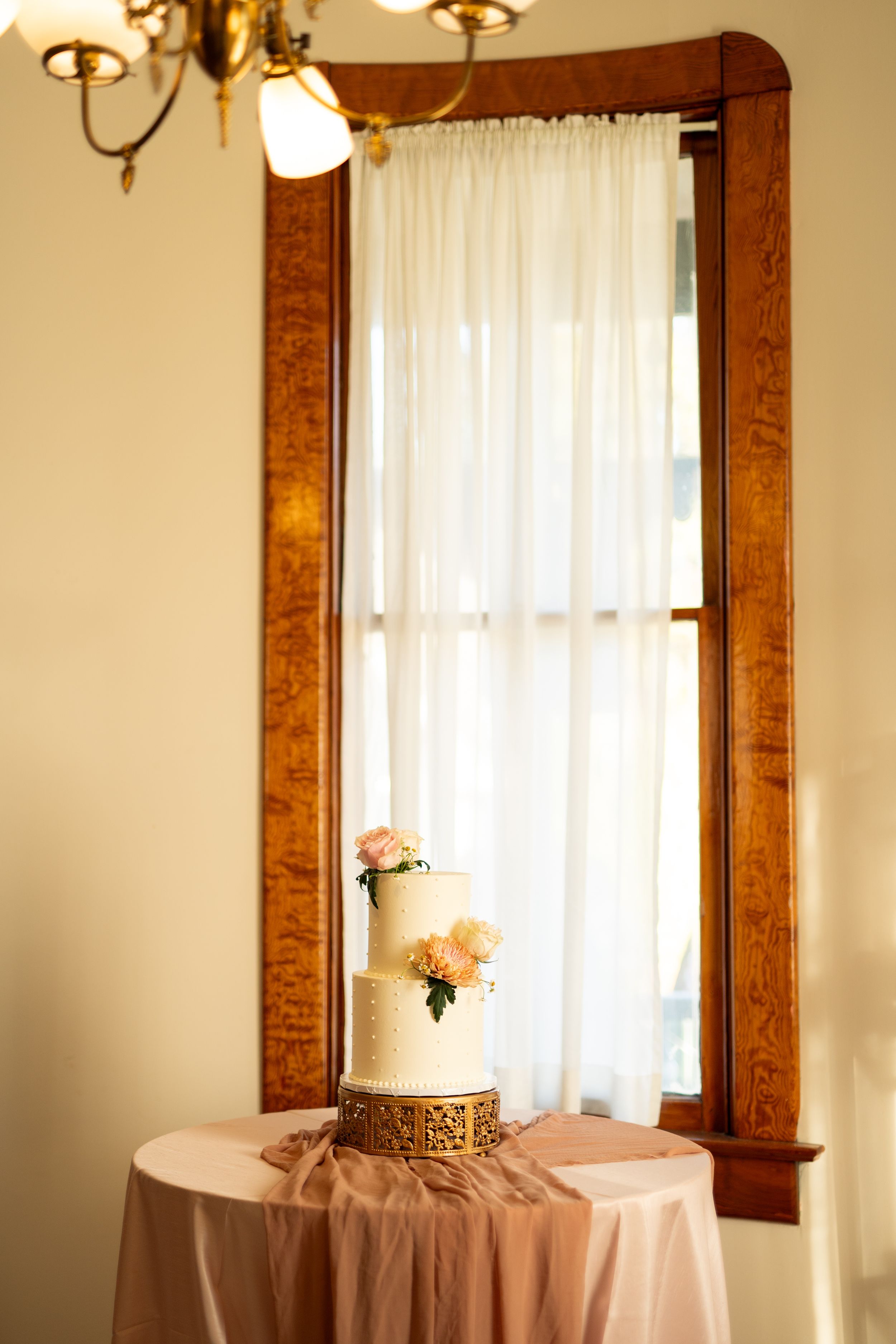Interior detail of wedding venue with warm wood trim and sheer curtains.