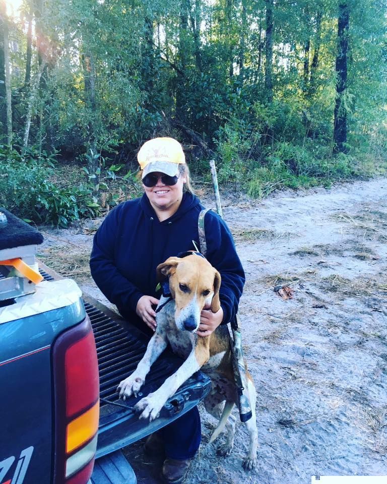 The author stands next to the tailgate with her foxhound deer dog during a South Carolina deer hunt.