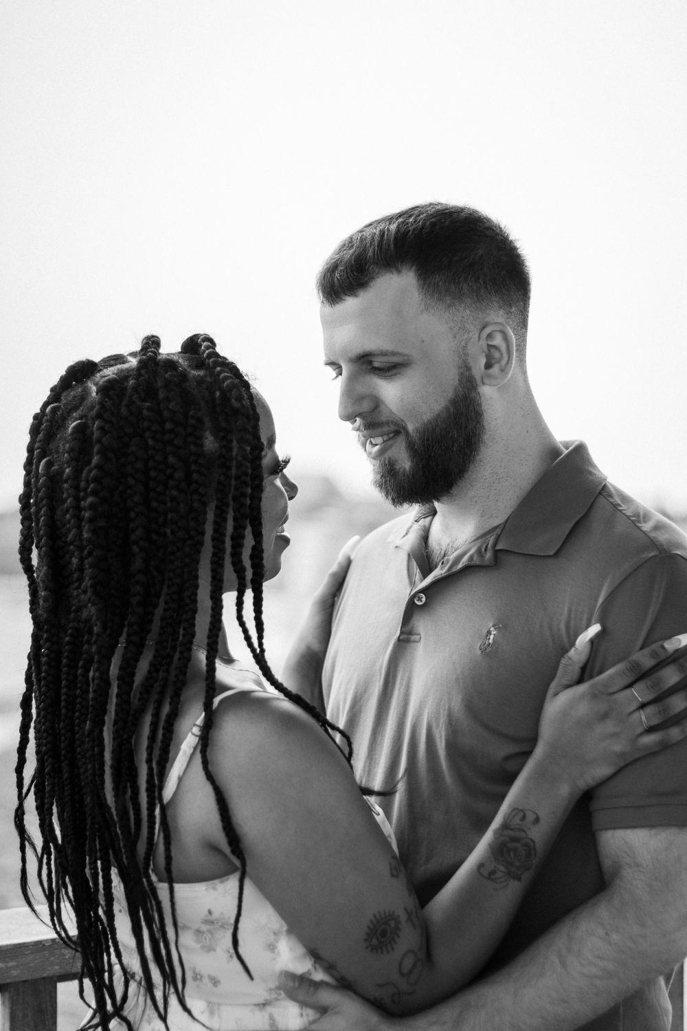 Black and white portrait of couple embracing outdoors.