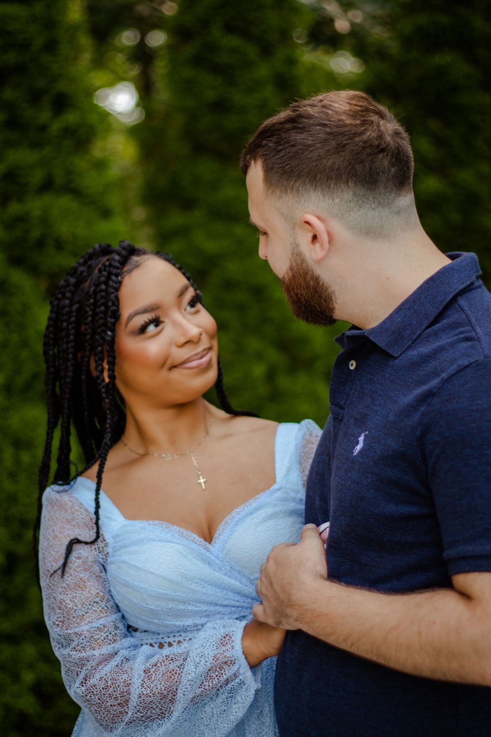 Couple shares intimate moment in outdoor garden setting.