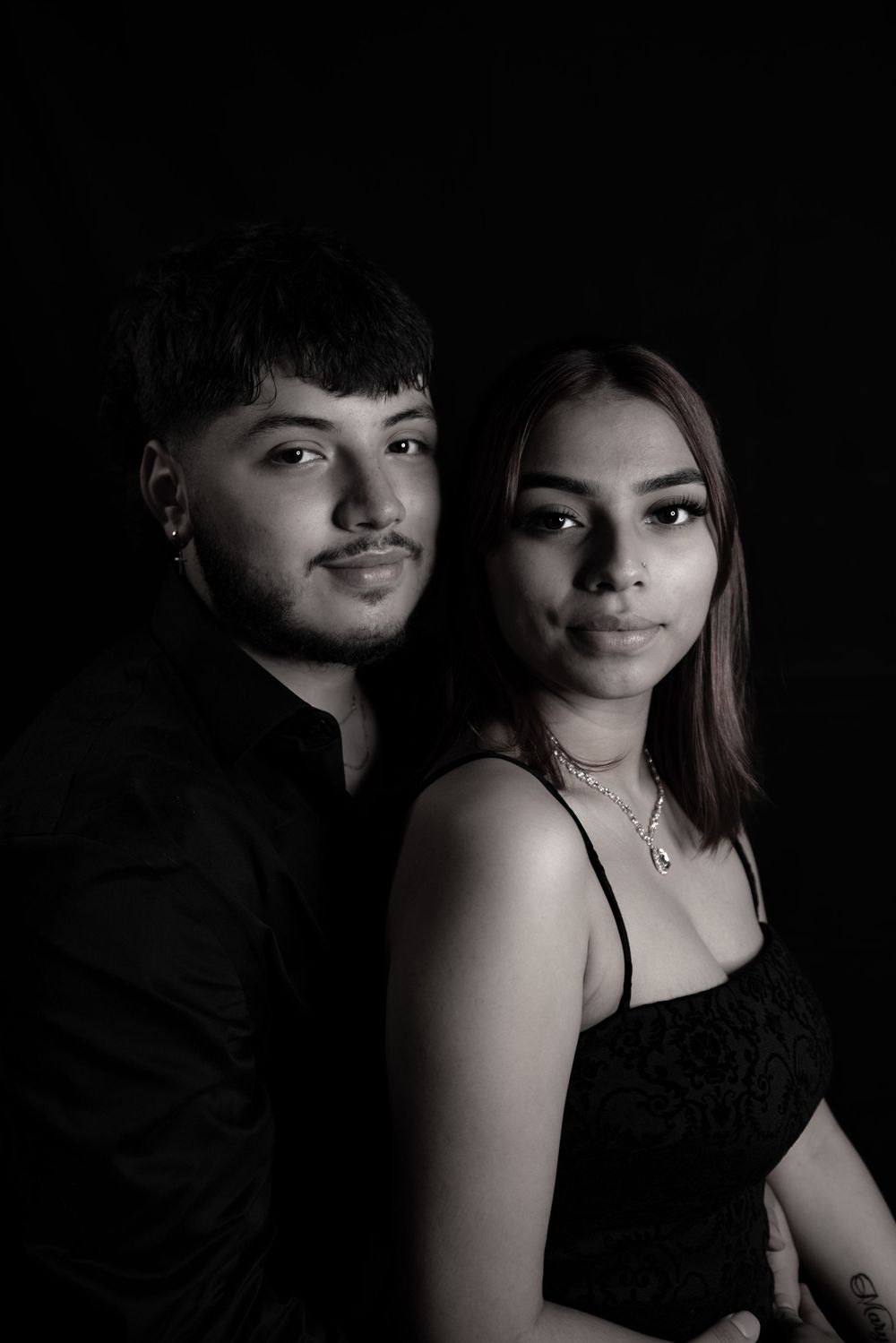 Artistic black and white portrait of a couple in elegant evening wear.