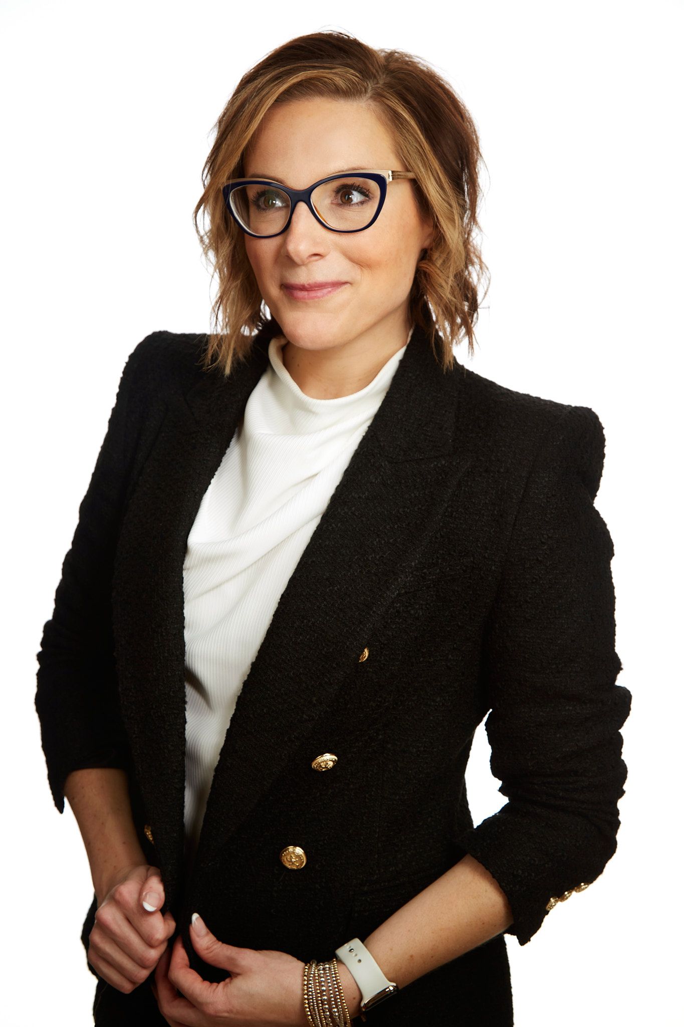 Professional headshot wearing a black blazer, white top and stylish glasses.