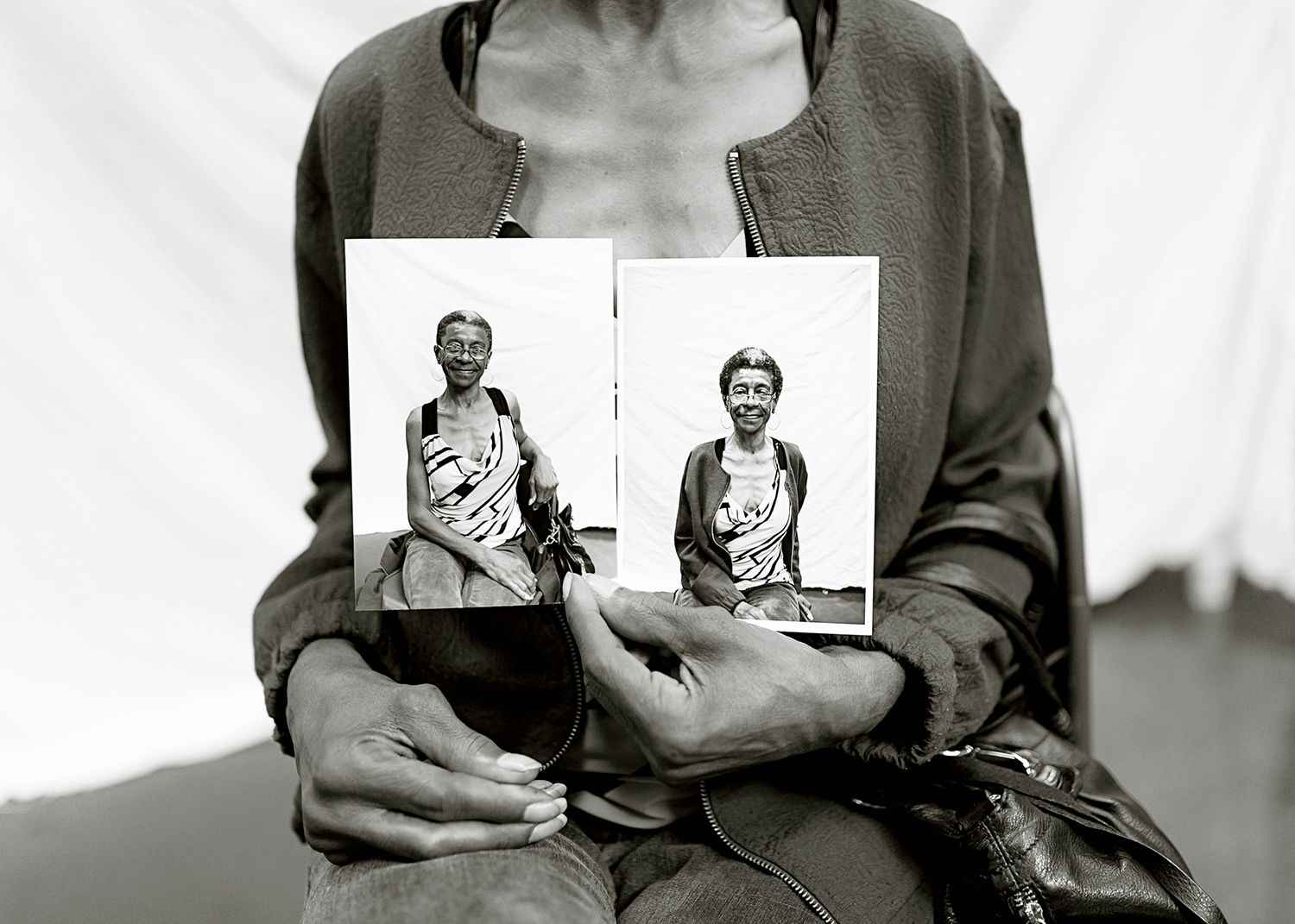 Project homeless connect Kansas City portraits station woman holding her two prints