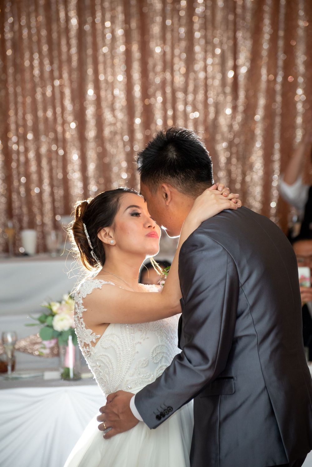 Romantic dance sequence against a sparkly rose gold sequin backdrop.