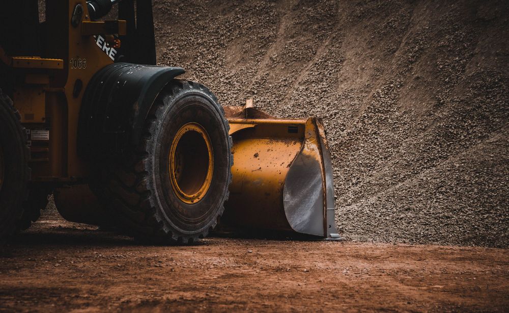 Construction machinery with large wheels working on a dirt surface.