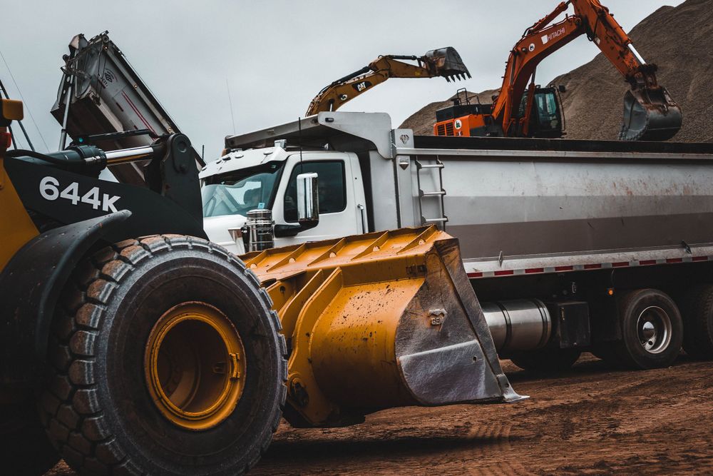 Heavy duty construction equipment and machinery parts shown in detail against a neutral background.
