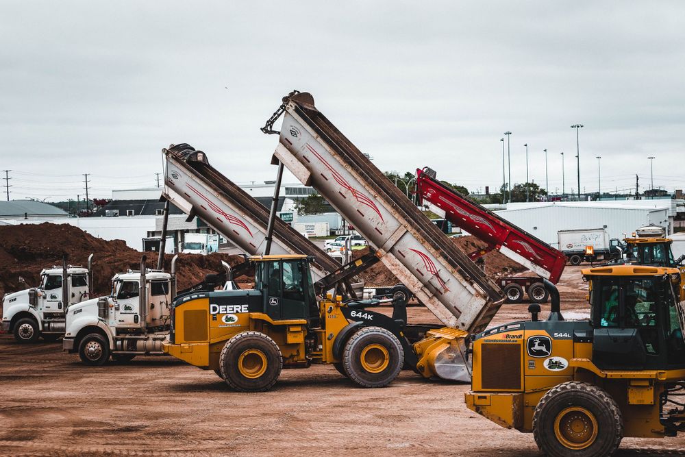Yellow wheel loaders and conveyor systems working at aggregate processing facility.